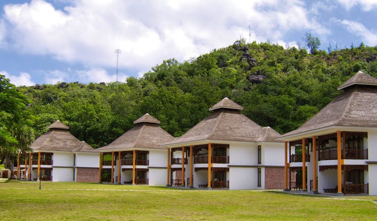 Domaine de la Reserve Seychelles villas white buildings with pointed thatched rooves gardens forest