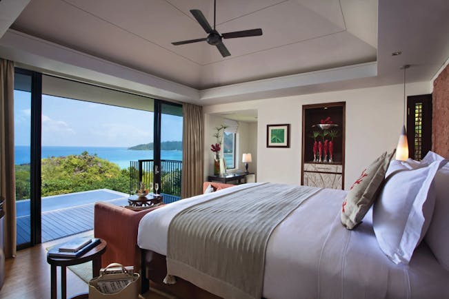 Raffles Praslin ocean view villa bedroom, bed, doors out to private terrace, modern decor, views across the ocean