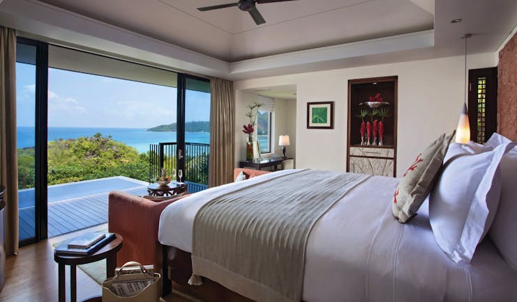 Raffles Praslin ocean view villa bedroom, bed, doors out to private terrace, modern decor, views across the ocean