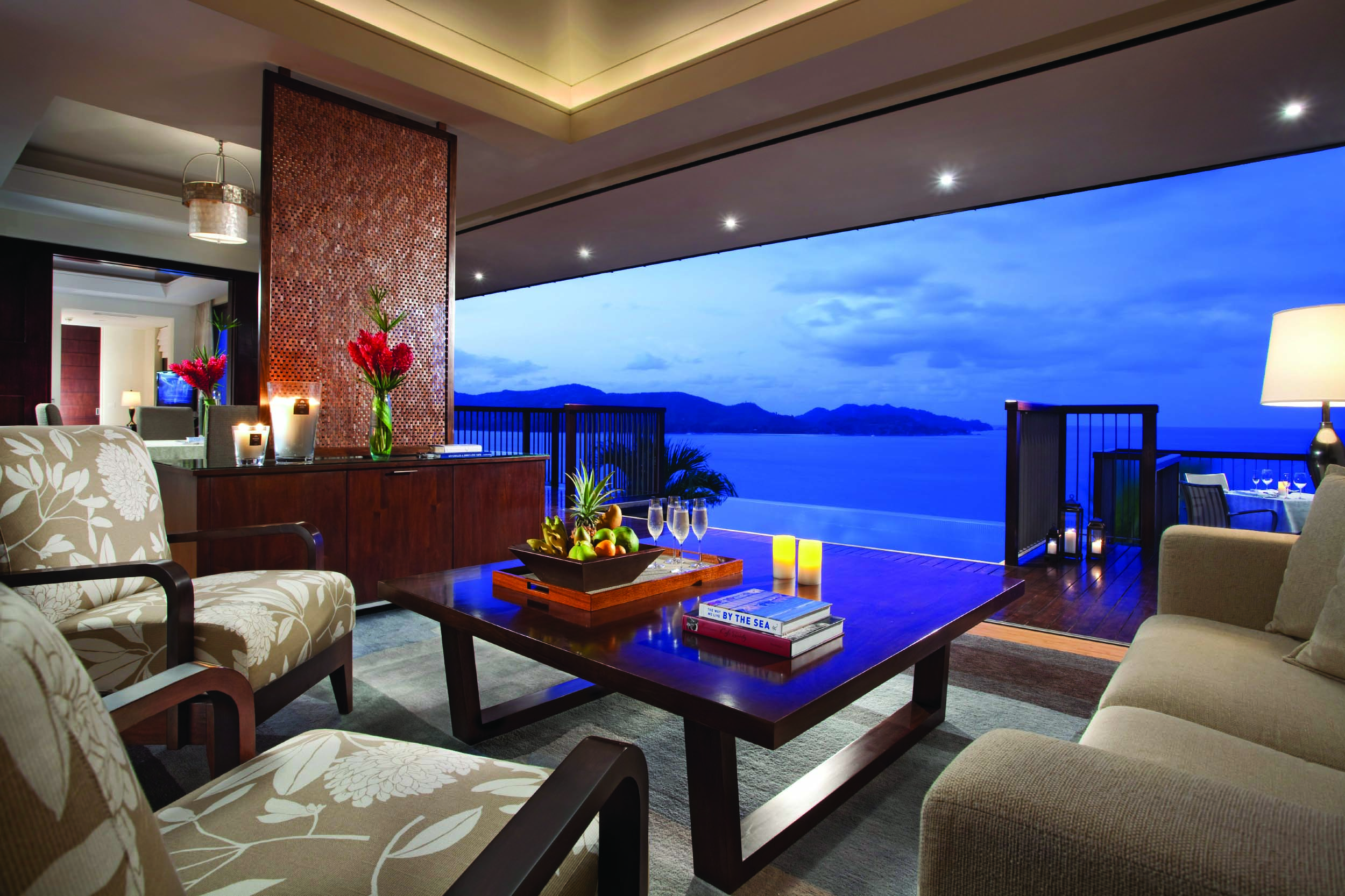 Raffles Praslin royal suite lounge area, sofas, armchairs, open wall with views out across the sea