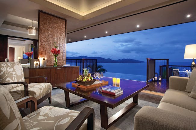 Raffles Praslin royal suite lounge area, sofas, armchairs, open wall with views out across the sea
