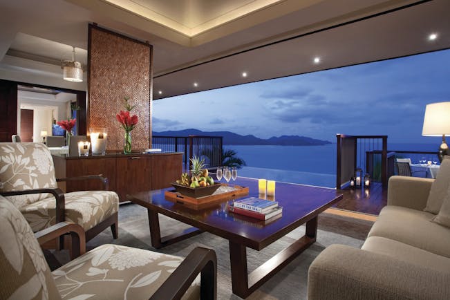 Raffles Praslin royal suite lounge area, sofas, armchairs, open wall with views out across the sea