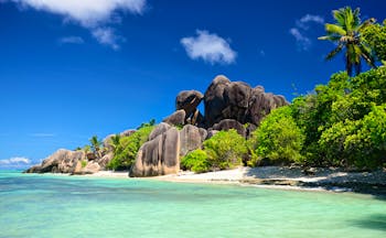 Rock formation and white sandy beach with turquoise blue sea in the Seychelles