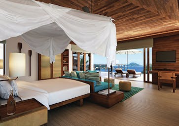 Six Senses Zil Pasyon villa bedroom, bed, sofa, fresh modern decor, terrace with sun loungers and ocean views