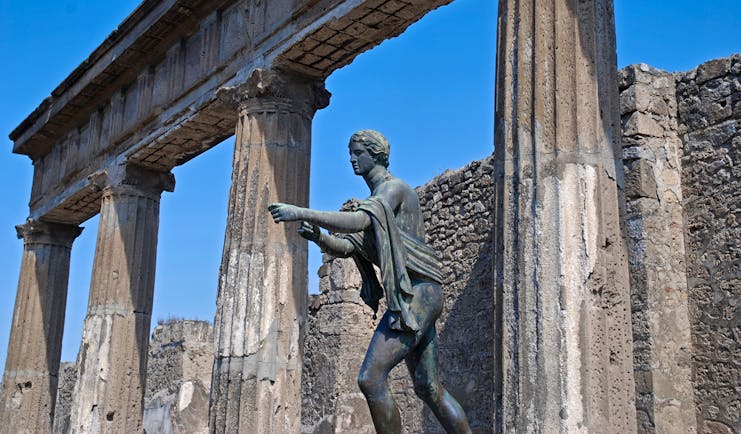 Statue of Apollo stretching out arm at Roman temple in Pompeii