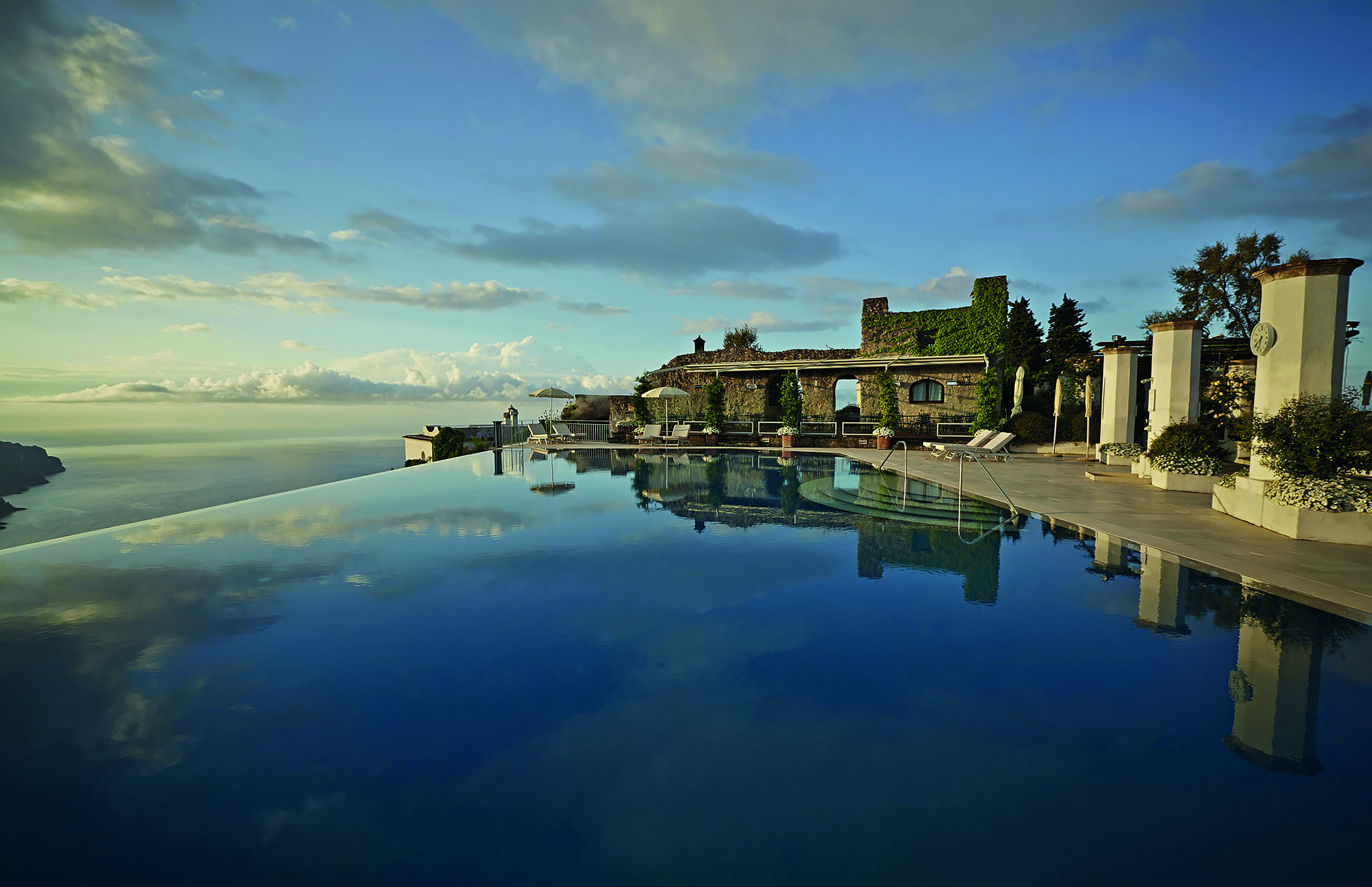 Hotel Caruso Amalfi Coast infinity pool area cky reflecting in pool water seating area