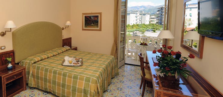 Hotel Antiche Mura Amalfi Coast comfort room double bed doors leading to balcony with table and chairs