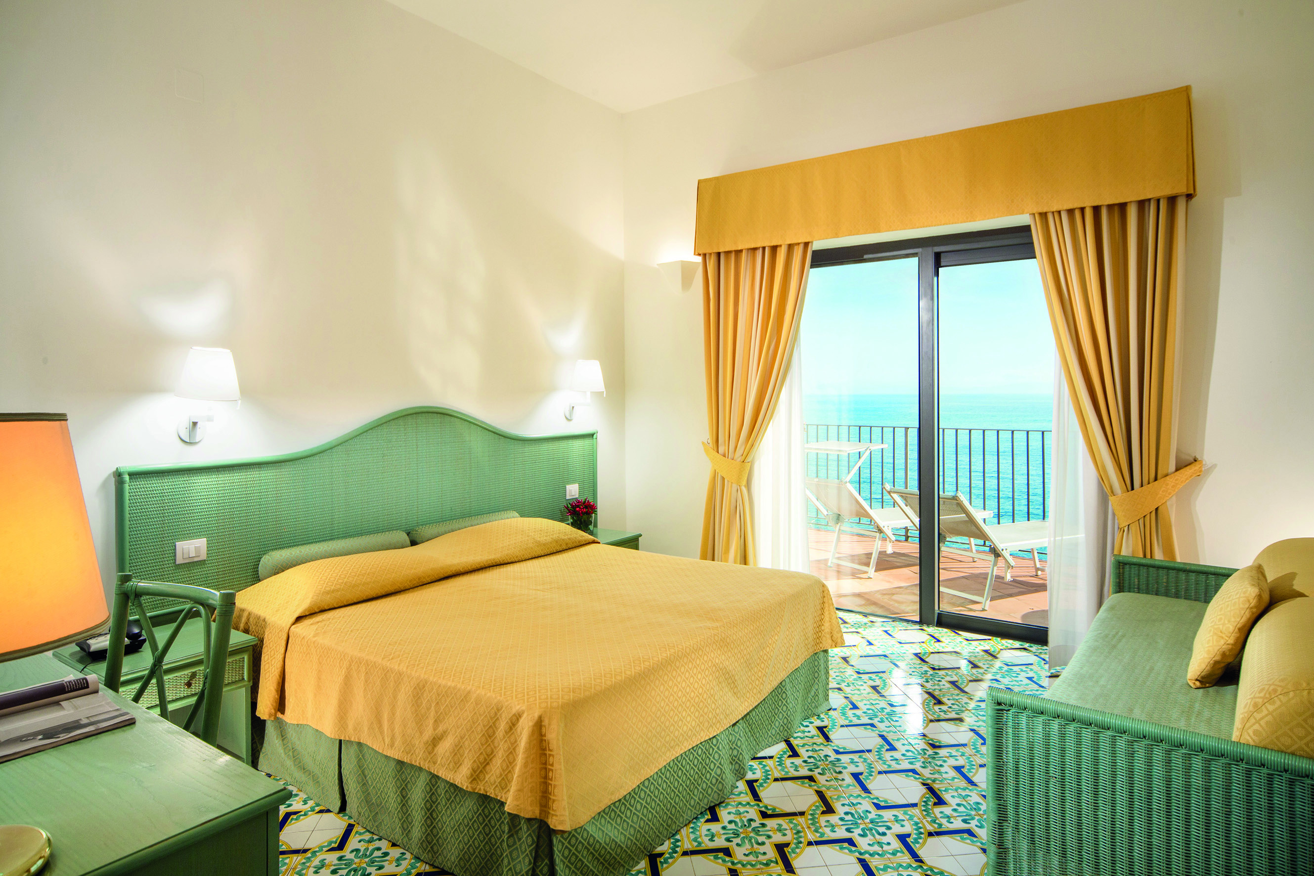 Hotel Miramalfi Amalfi Coast bedroom tiled floors yellow bedding balcony with outdoor seating