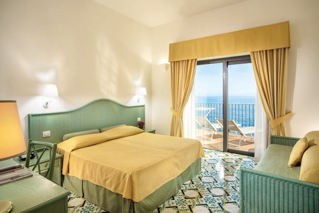 Hotel Miramalfi Amalfi Coast bedroom tiled floors yellow bedding balcony with outdoor seating