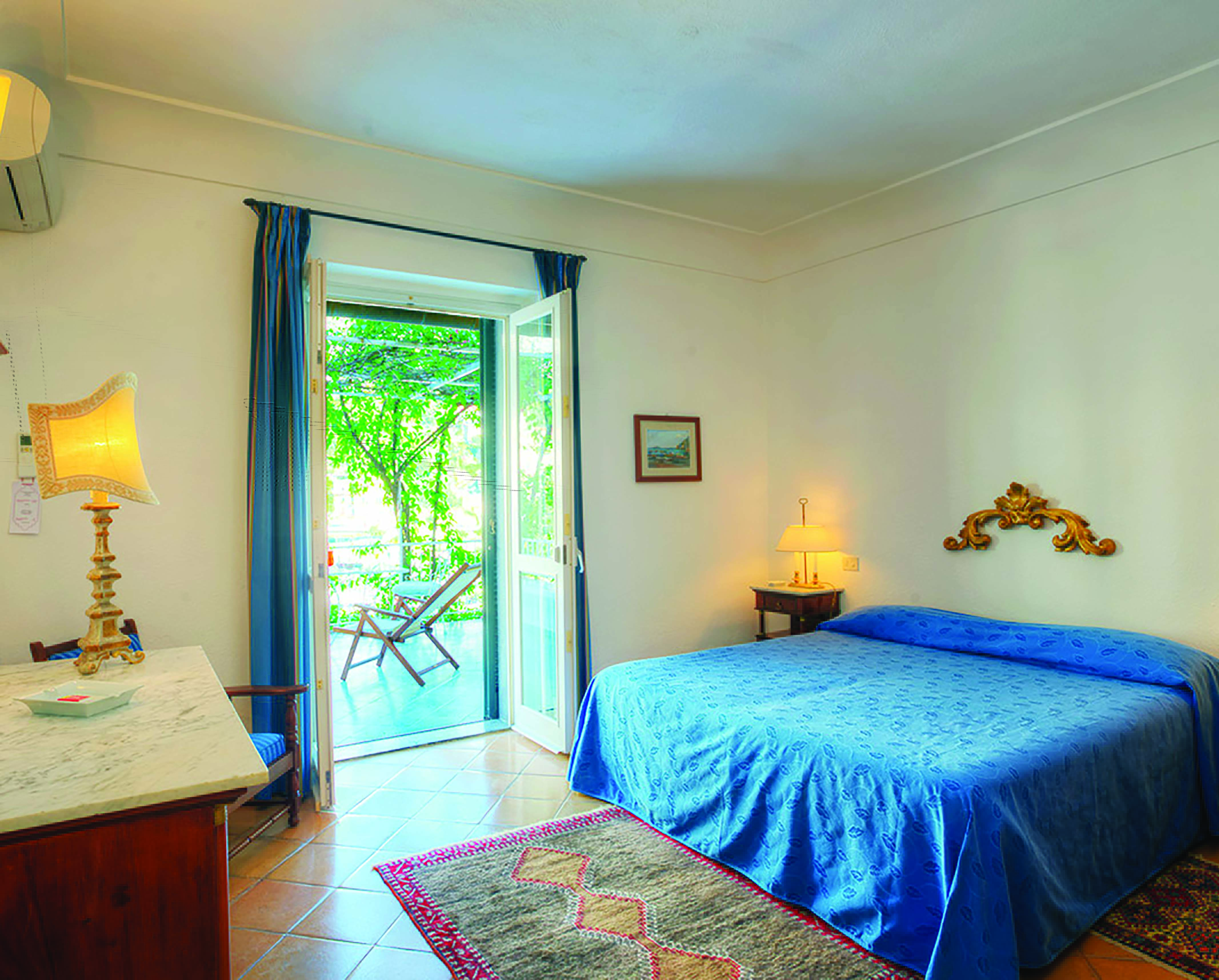Hotel Poseidon Amalfi Coast superior junior suite bedroom doors leading to outdoor seating area balcony
