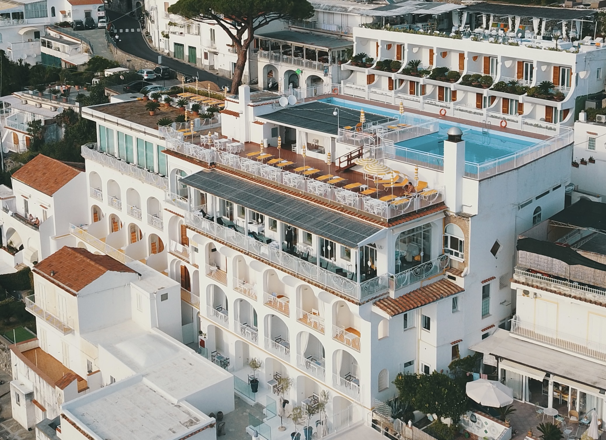 Hotel Tramonto d'Oro exterior aerial view showing the white-washed walls, the rooftop pool, and the seaview balconies