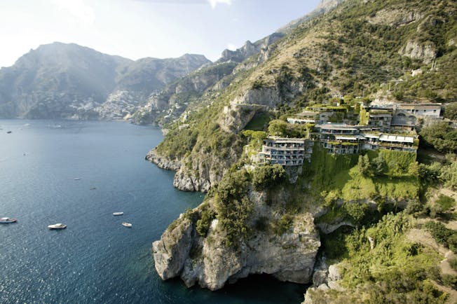 Bird's eye view of the Il San Pietro Di Positano shown on the edge of the sea in the mountains 