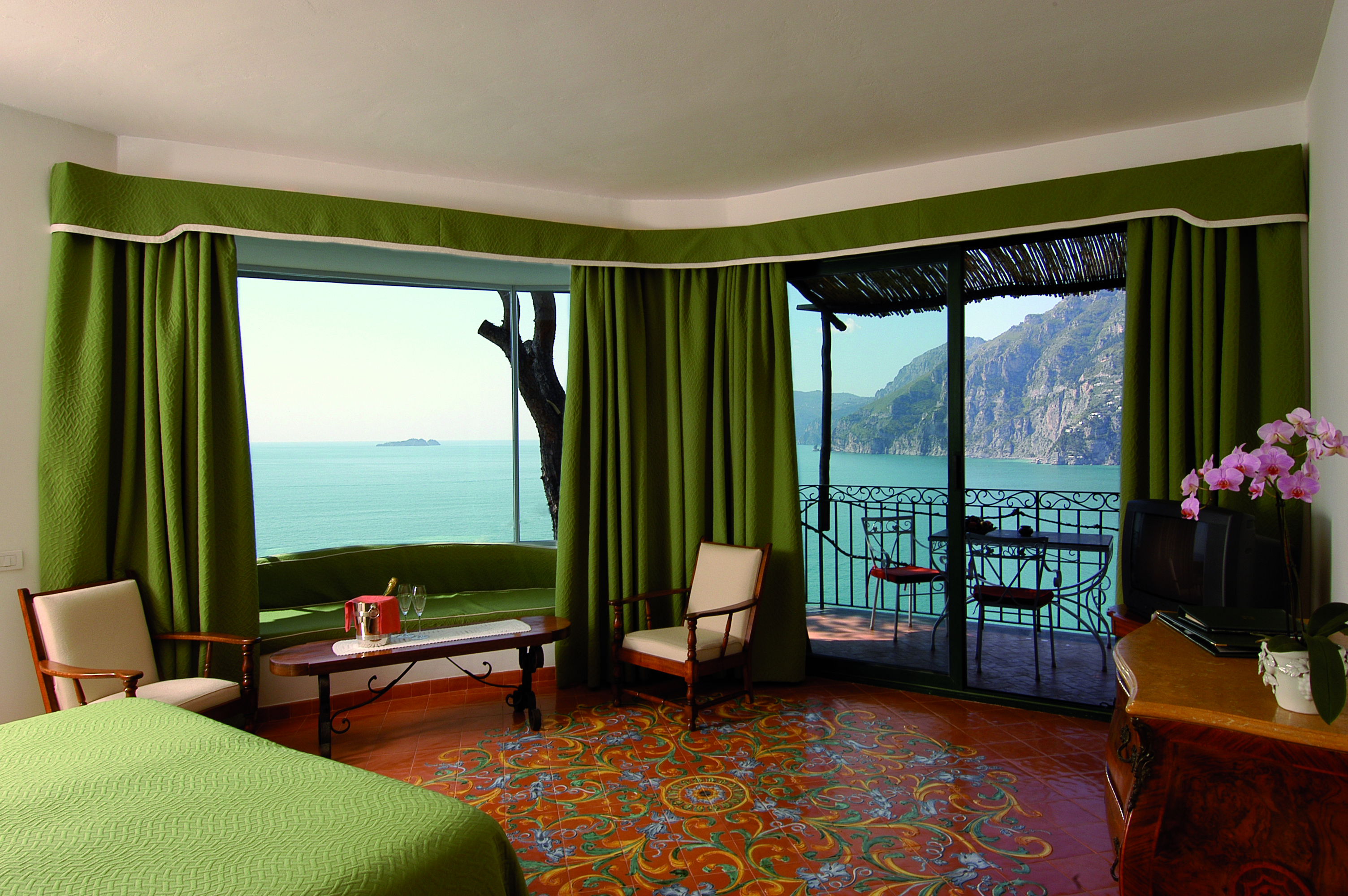 Suite in the Il San Pietro Di Positano with a double bed, sea views and a green colour scheme