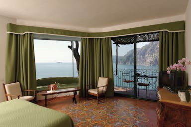 Suite in the Il San Pietro Di Positano with a double bed, sea views and a green colour scheme