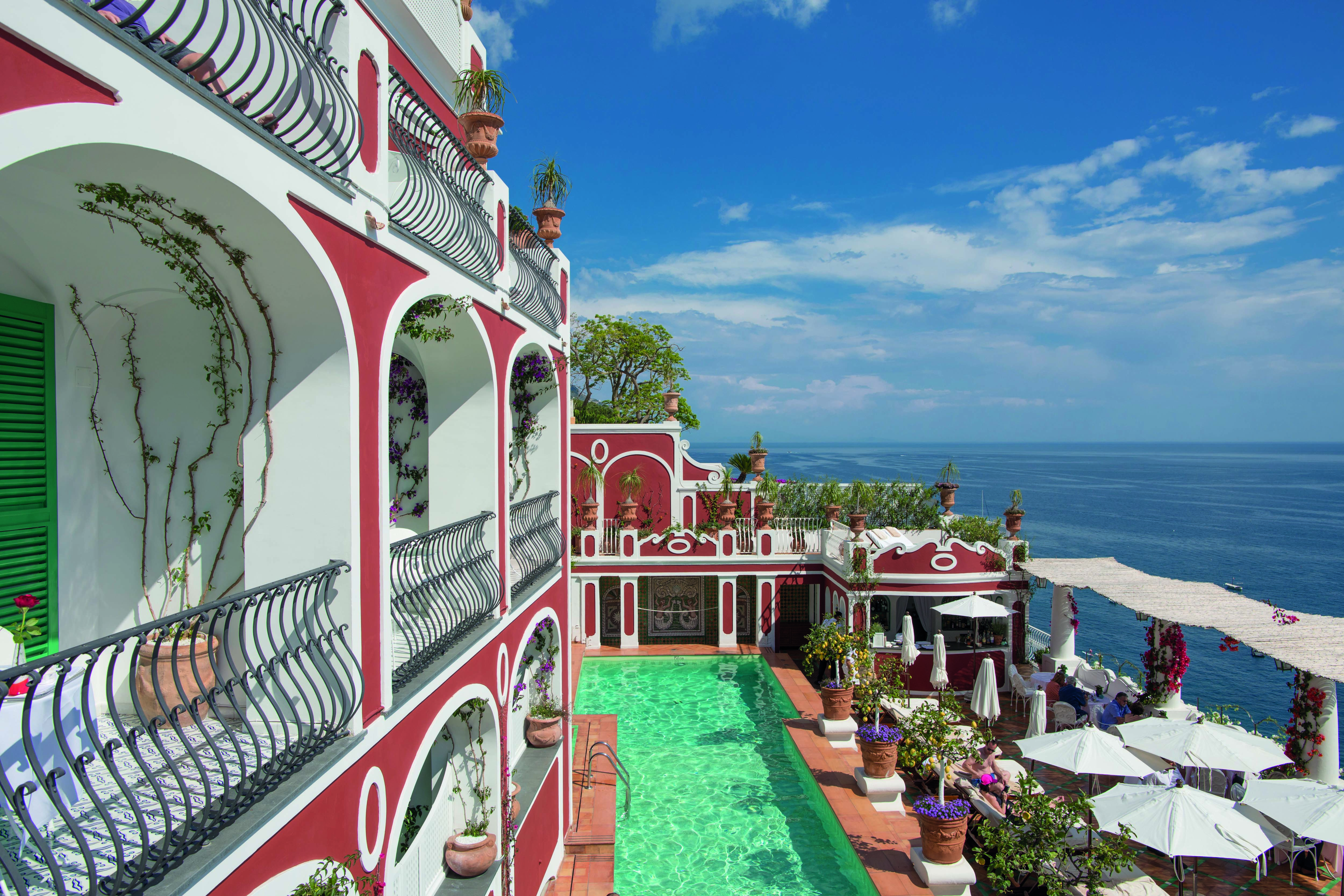 Le Sirenuse Amalfi Coast hotel exterior red building balconies pool ocean in the background