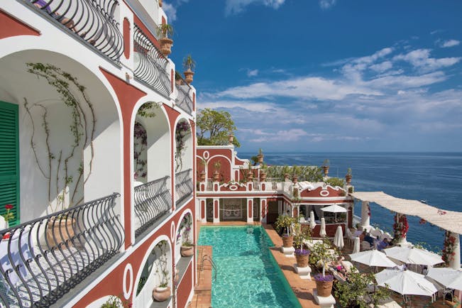 Le Sirenuse Amalfi Coast hotel exterior red building balconies pool ocean in the background