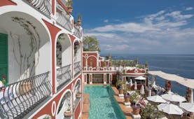 Le Sirenuse Amalfi Coast hotel exterior red building balconies pool ocean in the background
