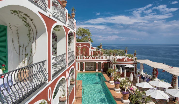 Le Sirenuse Amalfi Coast hotel exterior red building balconies pool ocean in the background
