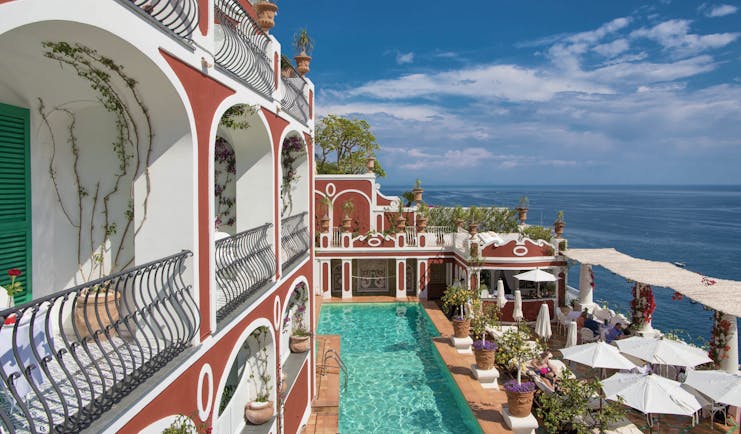 Le Sirenuse Amalfi Coast hotel exterior red building balconies pool ocean in the background