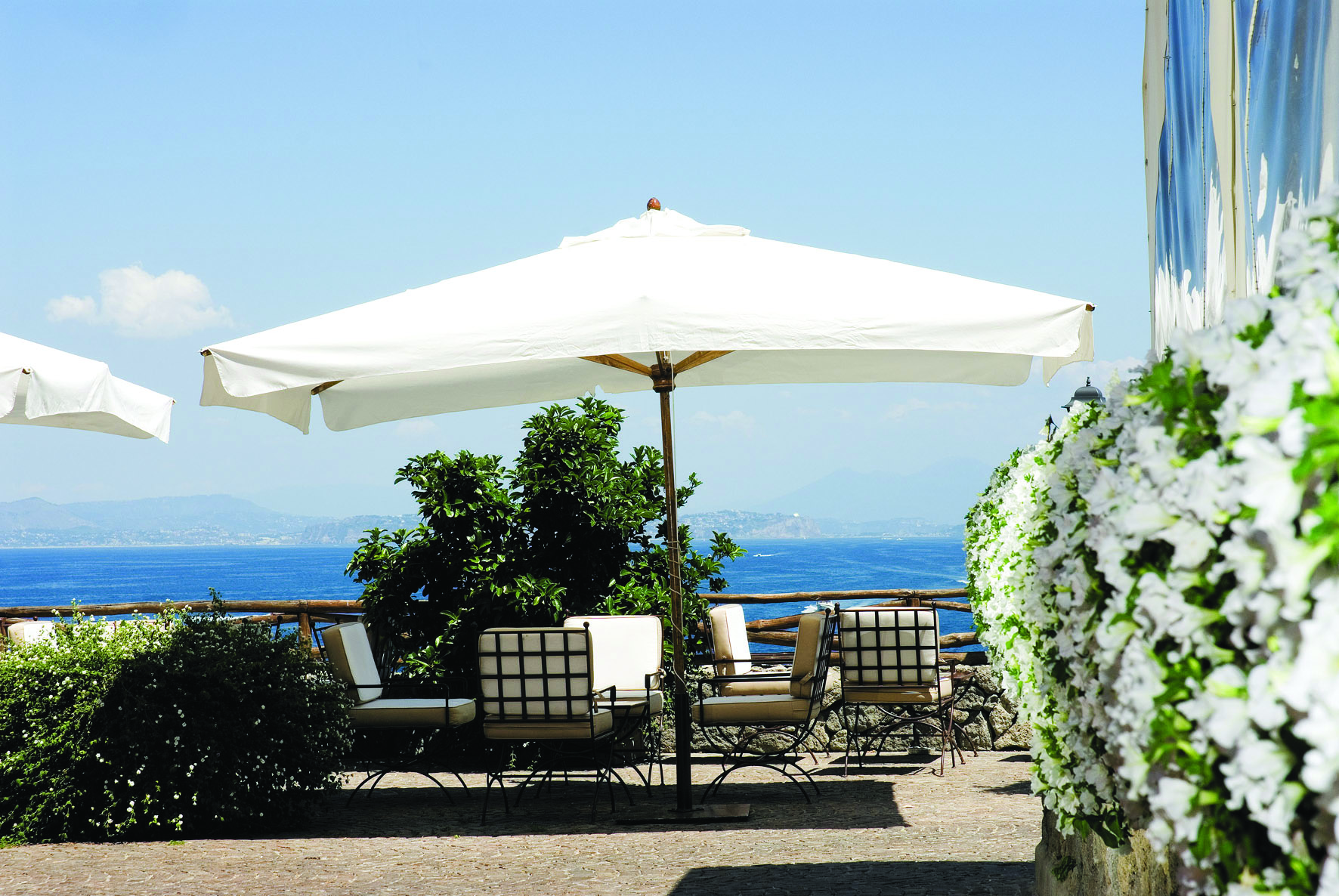 Mezzatorre Resort Amalfi Coast sun terrace outdoor seating area chairs umbrella view of sea