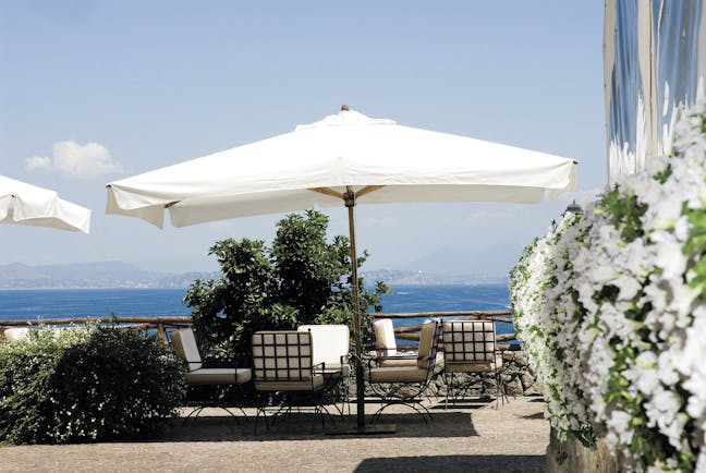 Mezzatorre Resort Amalfi Coast sun terrace outdoor seating area chairs umbrella view of sea
