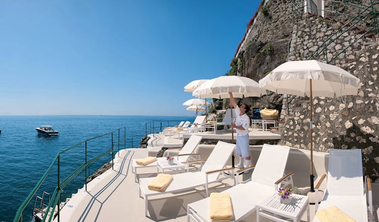 Palazzo Avino Amalfi Coast clubhouse sun loungers umbrellas boats on the water