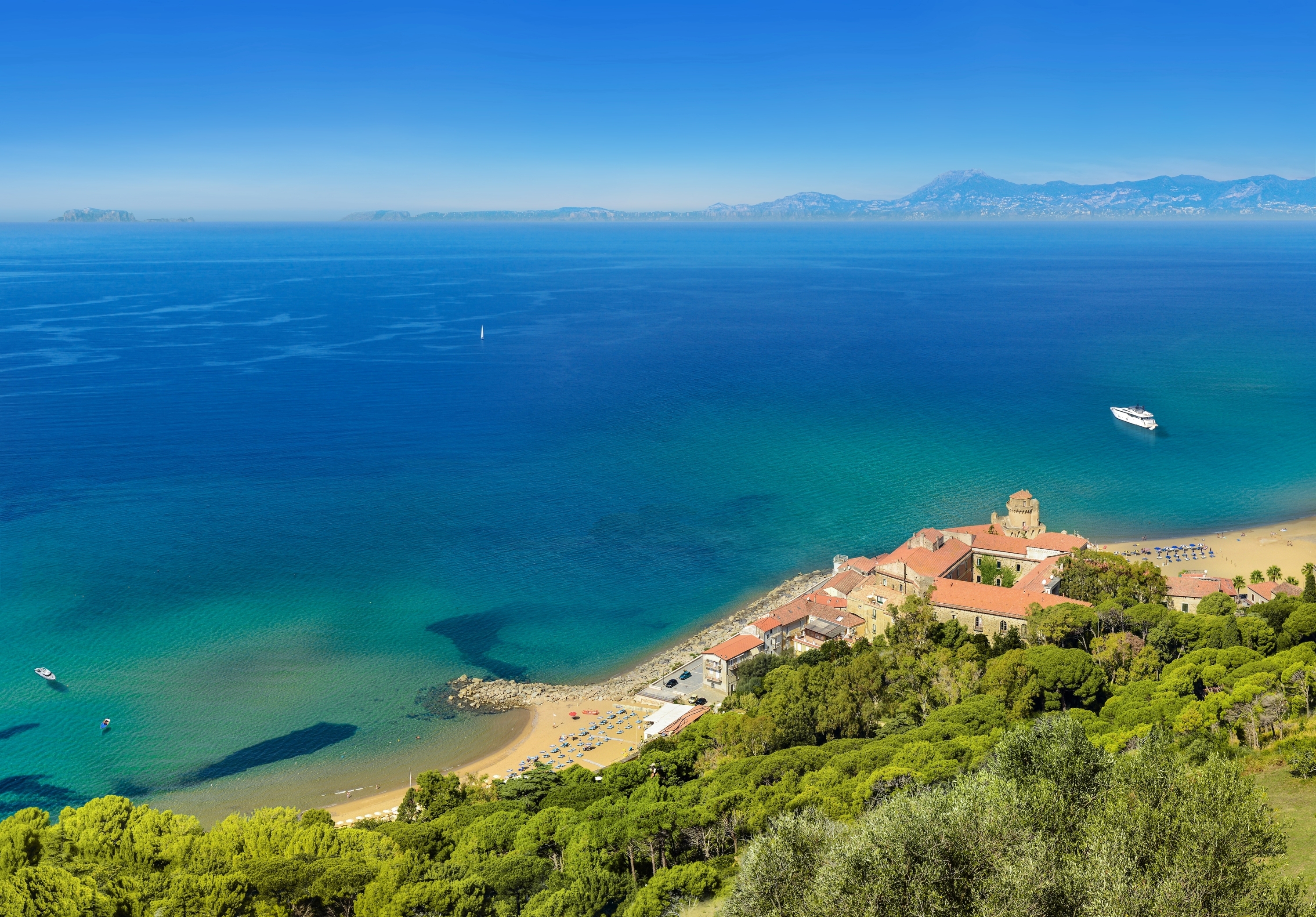 Aerial view of a sandy coast, historic building and trees
