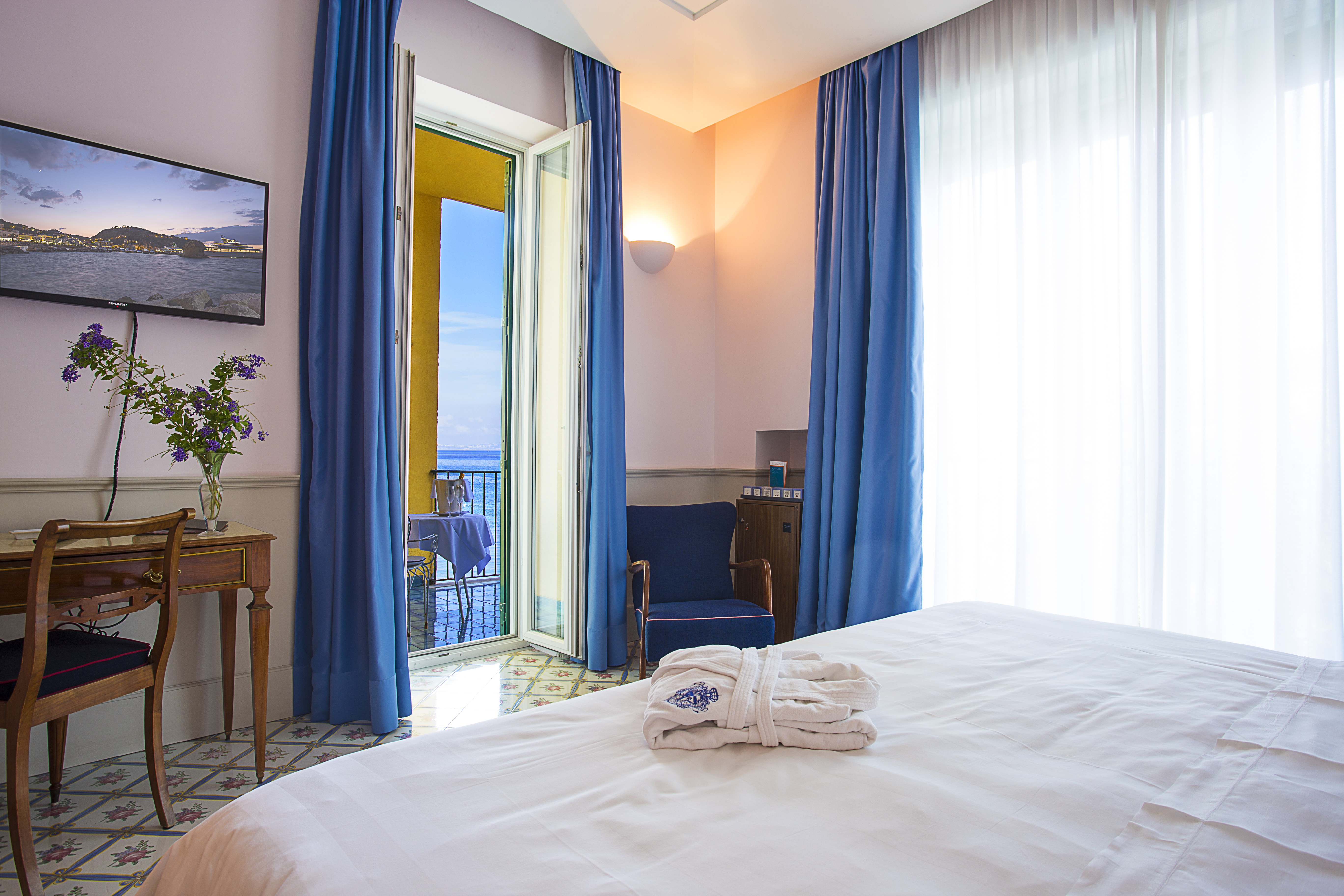 Regina Isabella junior suite, double bed, tiled floor, colourful elegant decor, access to private baclony overlooking sea