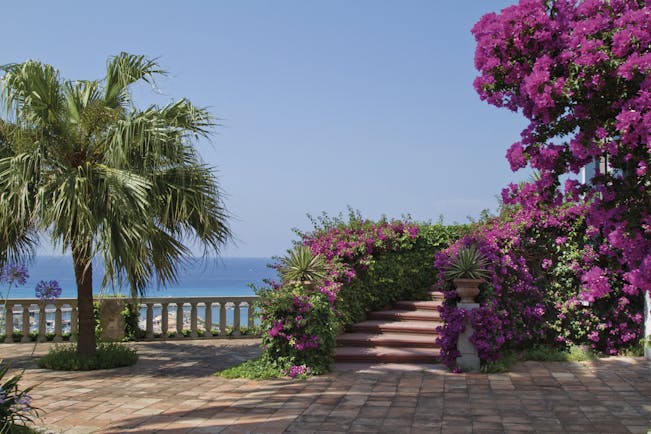 Villa Paola Calabria gardens trees pink flowers views of the sea