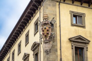 Stone carving of the emblem of the house of Medici on side of wall of building in florence