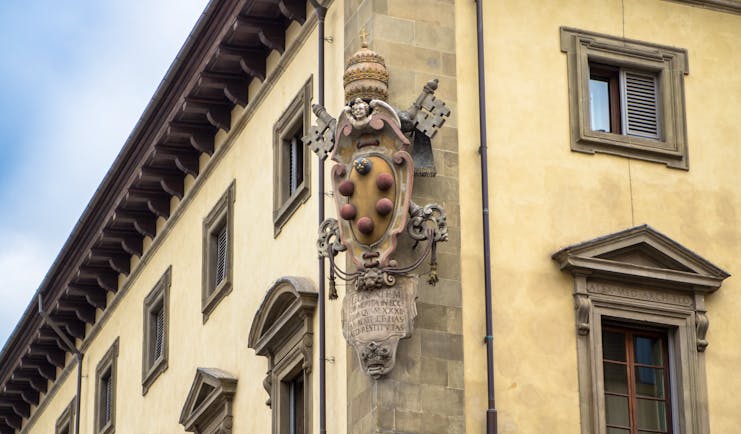 Stone carving of the emblem of the house of Medici on side of wall of building in florence