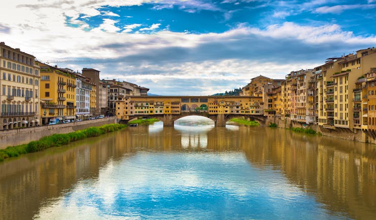 The river Arno with covered bridge Ponte Vecchio joining the two sides of the river in Florence