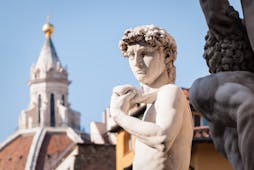 Statue of David with the terracotta cupola of the cathedral in Florence