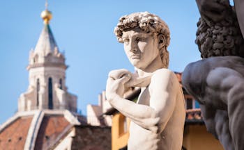 Statue of David with the terracotta cupola of the cathedral in Florence