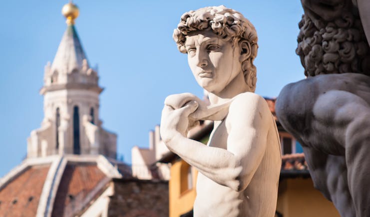 Statue of David with the terracotta cupola of the cathedral in Florence