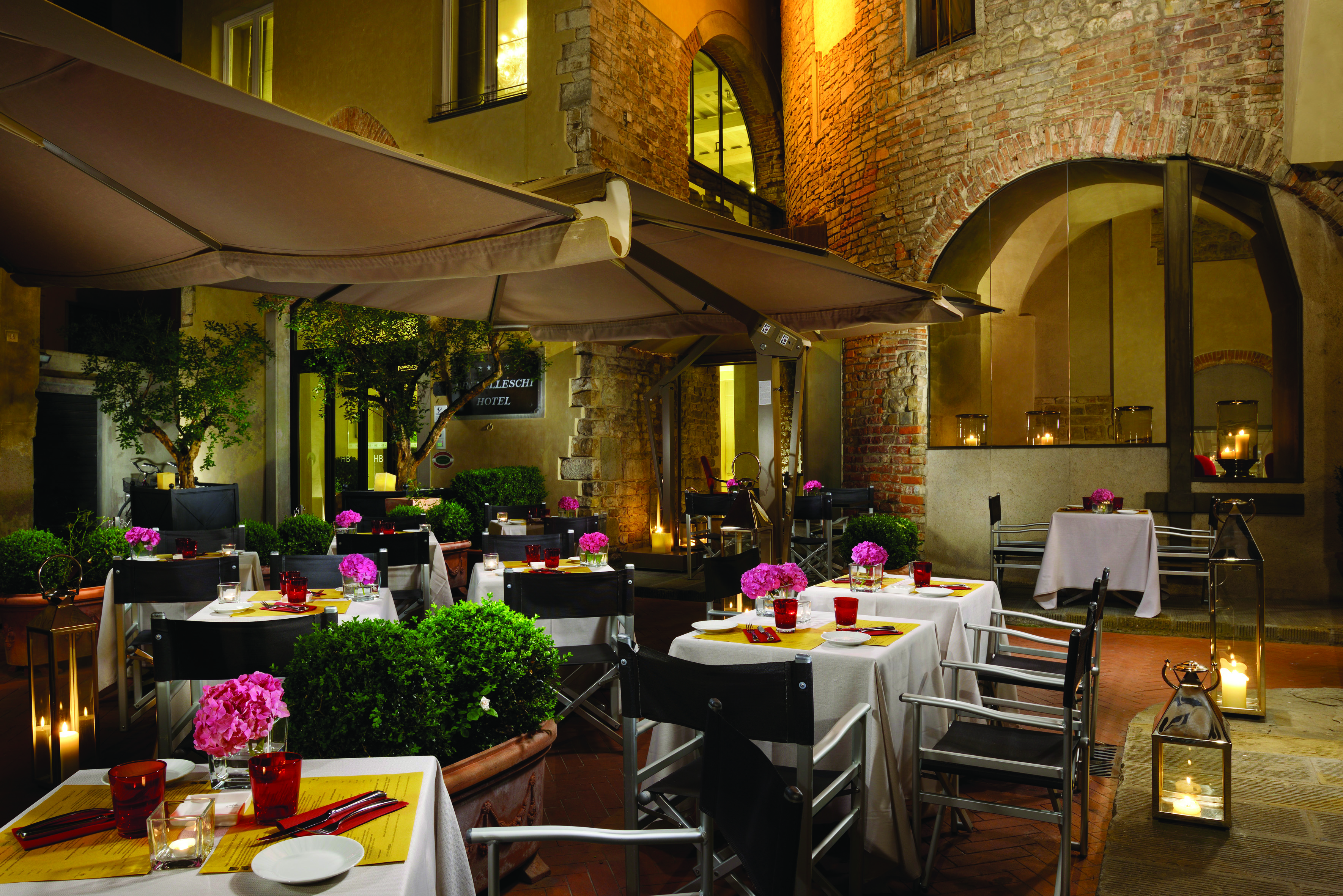 Hotel Brunelleschi Florence courtyard dining outdoor dining area tables set with candles pink flowers