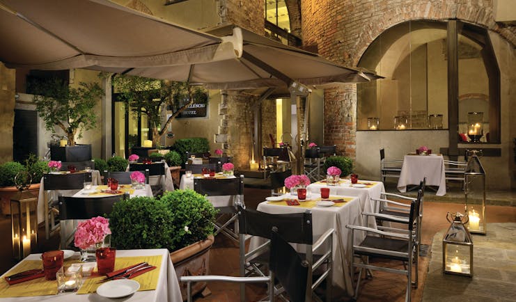 Hotel Brunelleschi Florence courtyard dining outdoor dining area tables set with candles pink flowers