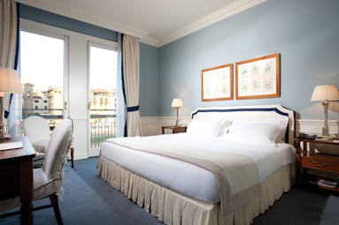 Bedroom with large double bed, blue colour scheme and balcony