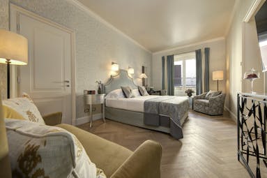 Grey furnishings and parquet floor of classic room at Hotel Savoy FLorence