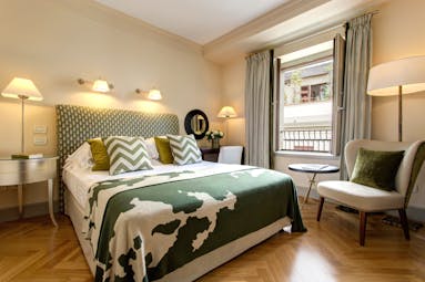 Green and white soft furnishings in bedroom with parquet wooden floor of executive room Hotel Savoy Florence