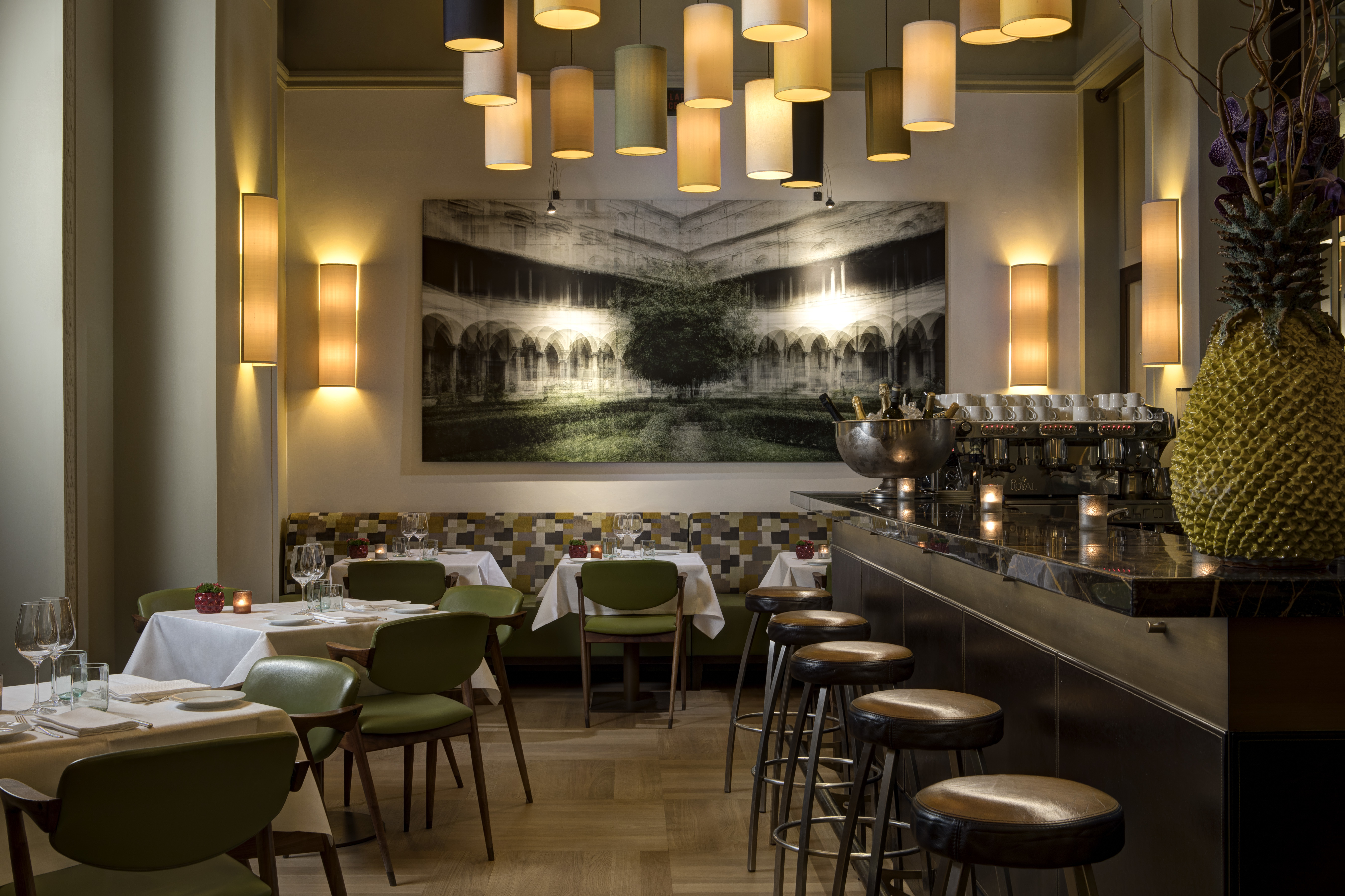 Warmly lit restaurant with leather stools and many lampshades at Hotel Savoy Florence