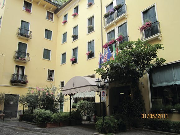 Majestic Toscanelli Padua hotel exterior yellow building juliet balconies window boxes with pink flowers