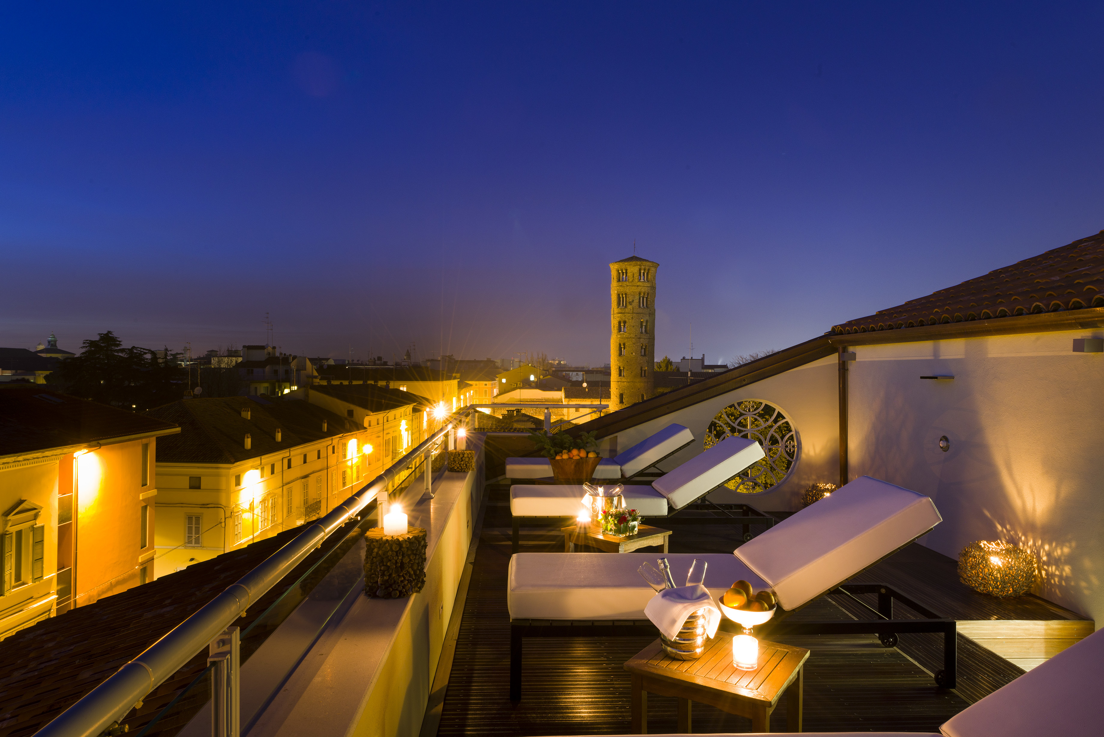 Hotel Palazzo Bezzi rooftop at night, with sun loungers looking over the rooftops of the city