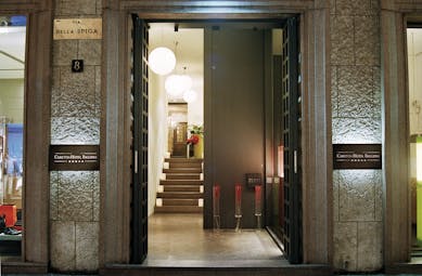 Front on view of the entrance to the hotel, showing the open doors leading up to a small wooden staircase