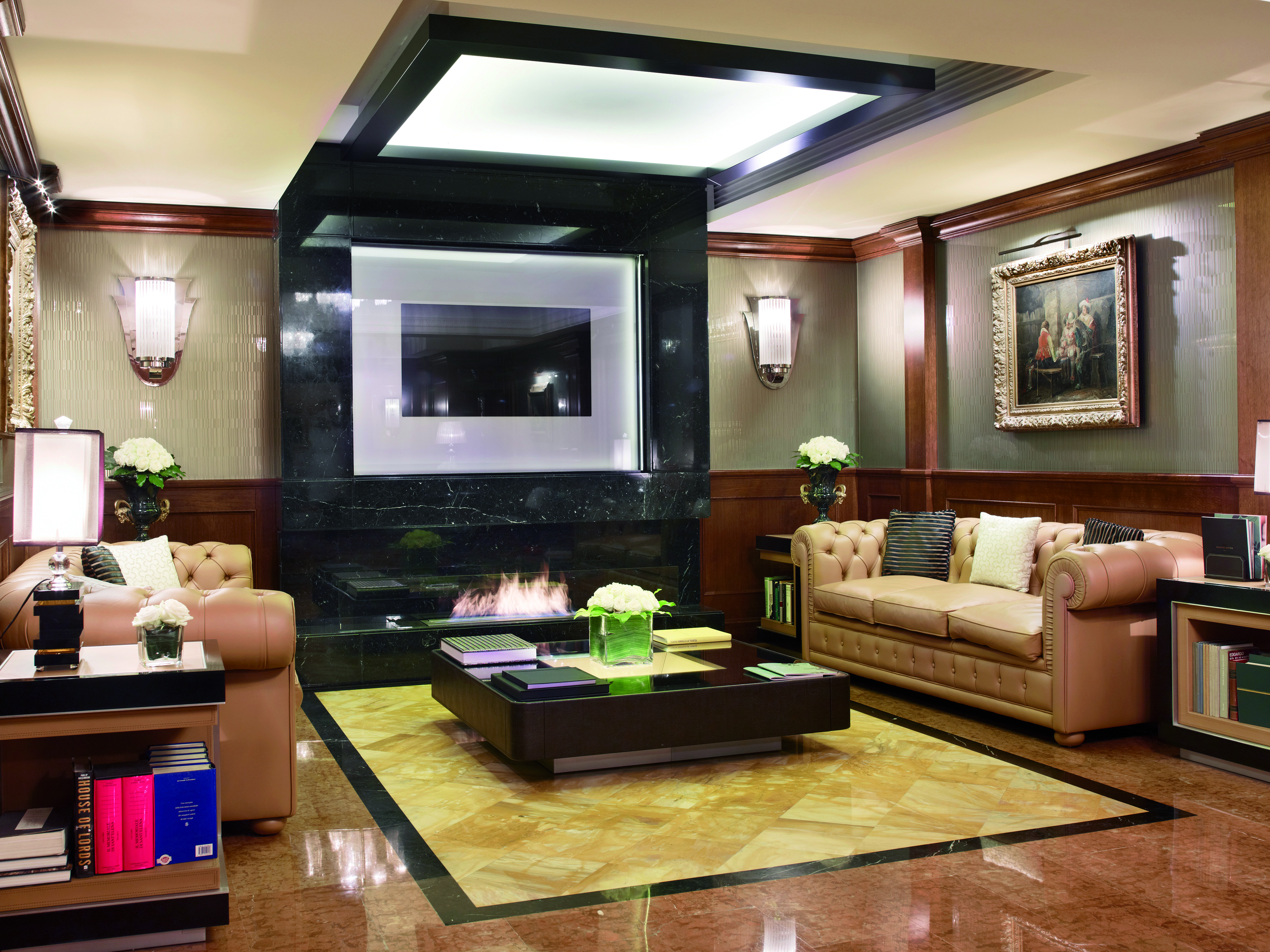 Baglioni Hotel Carlton lonny with leather sofas an electric fire and wooden wall pannels 
