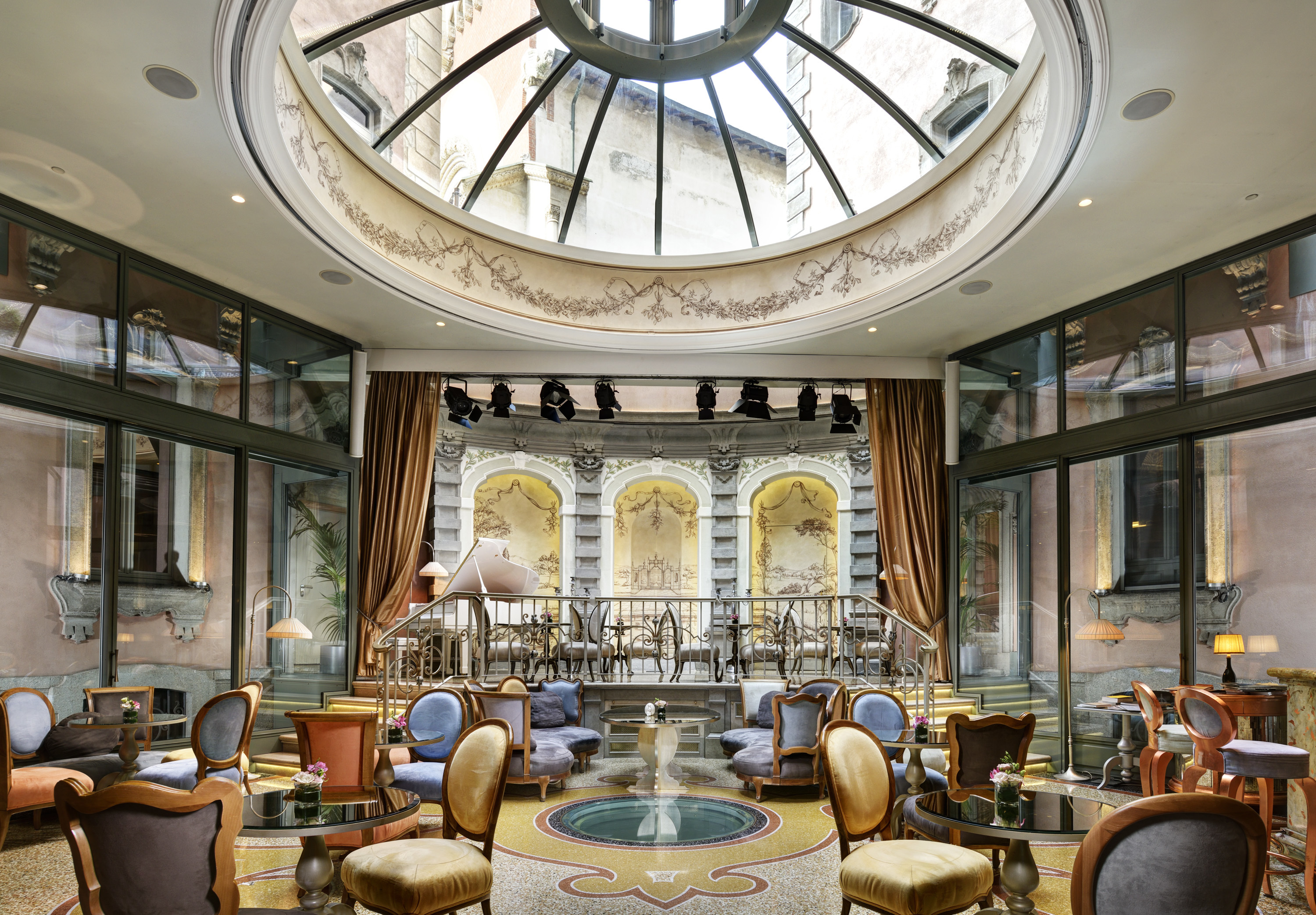 Chateau Monfort elegant hall, with circular domed window in the ceiling, grand furnishings, and glass walls