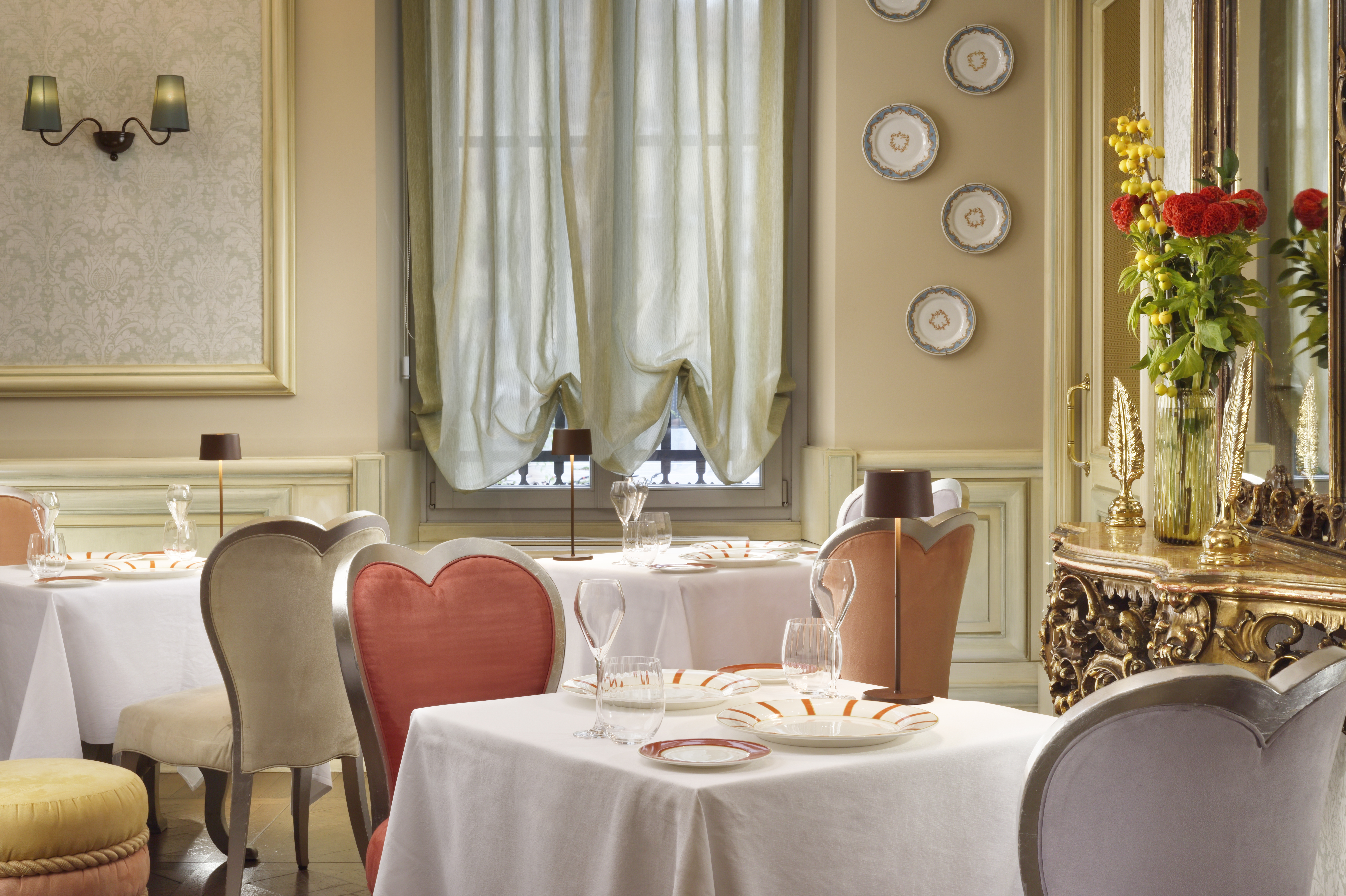 Chateau Monfort restaurant with neutral colour palette, heart-shaped chair backs, and white-clothed tables