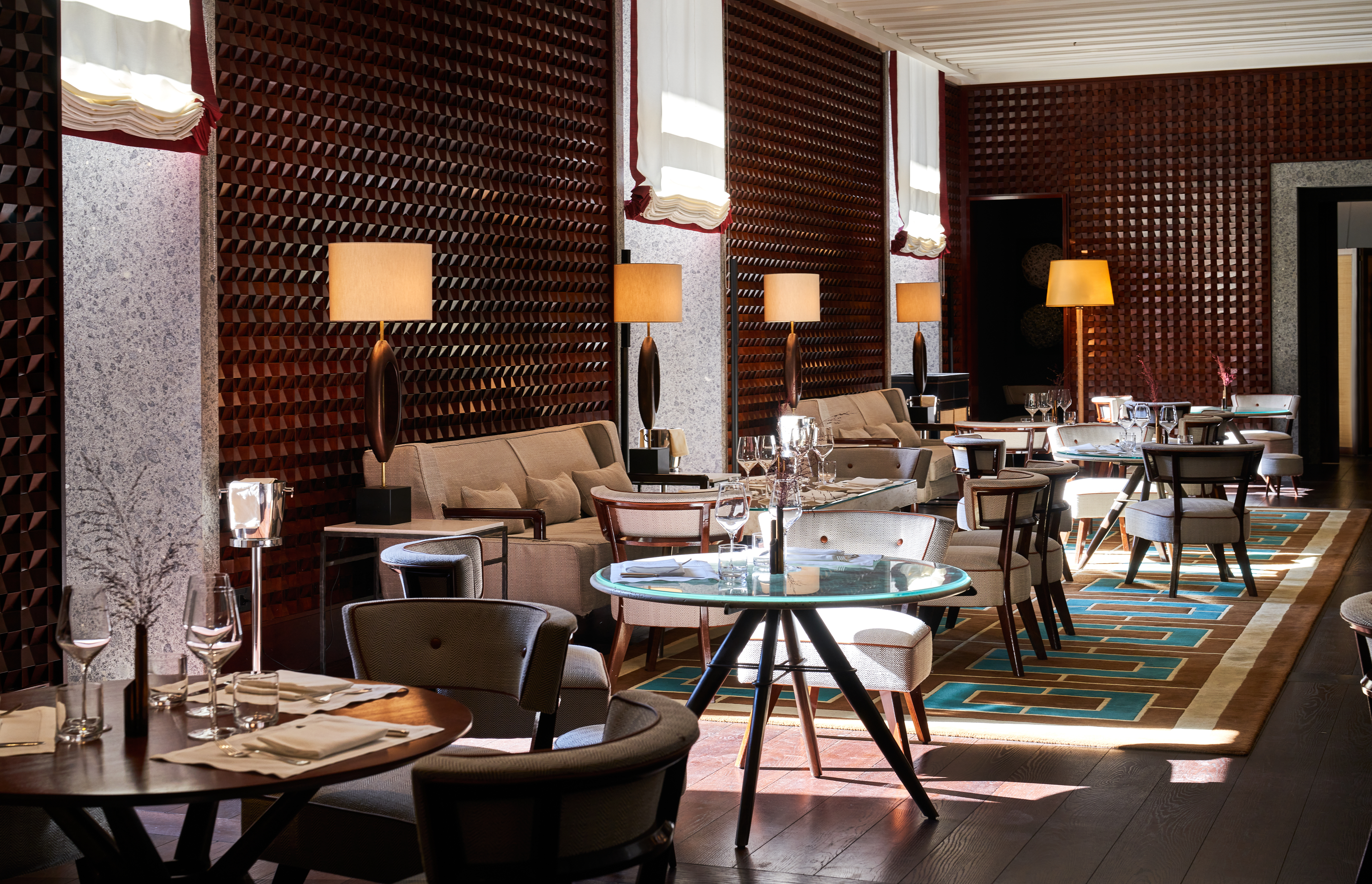 Hotel Portrait Milano 10_11 Bar with glass tables, white sofas, and textured red walls