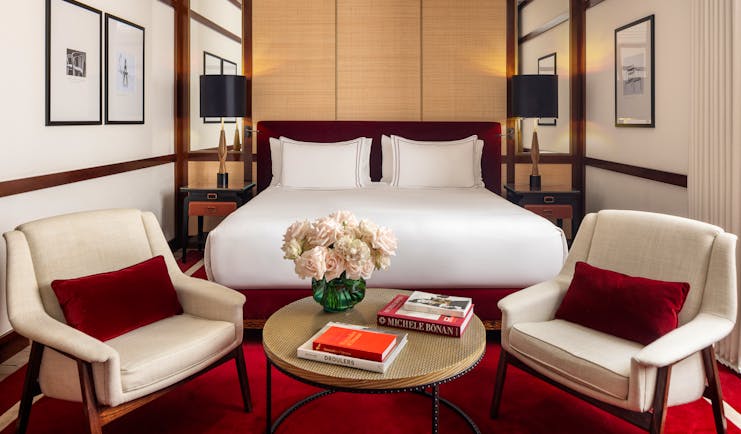 Hotel Portrait Milano Portrait Studio room decorated in red and white and dark wood, with a double bed and seating area