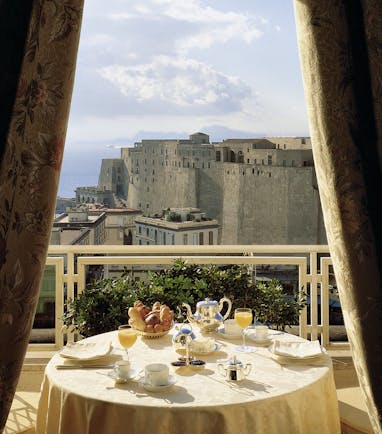 View of the Caruso Roof Garden Restaurant with a circular table on the balcony looking over Naples